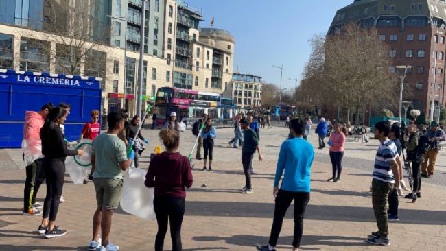 A group of plogging volunteers standing together at the Bristol waterfront.